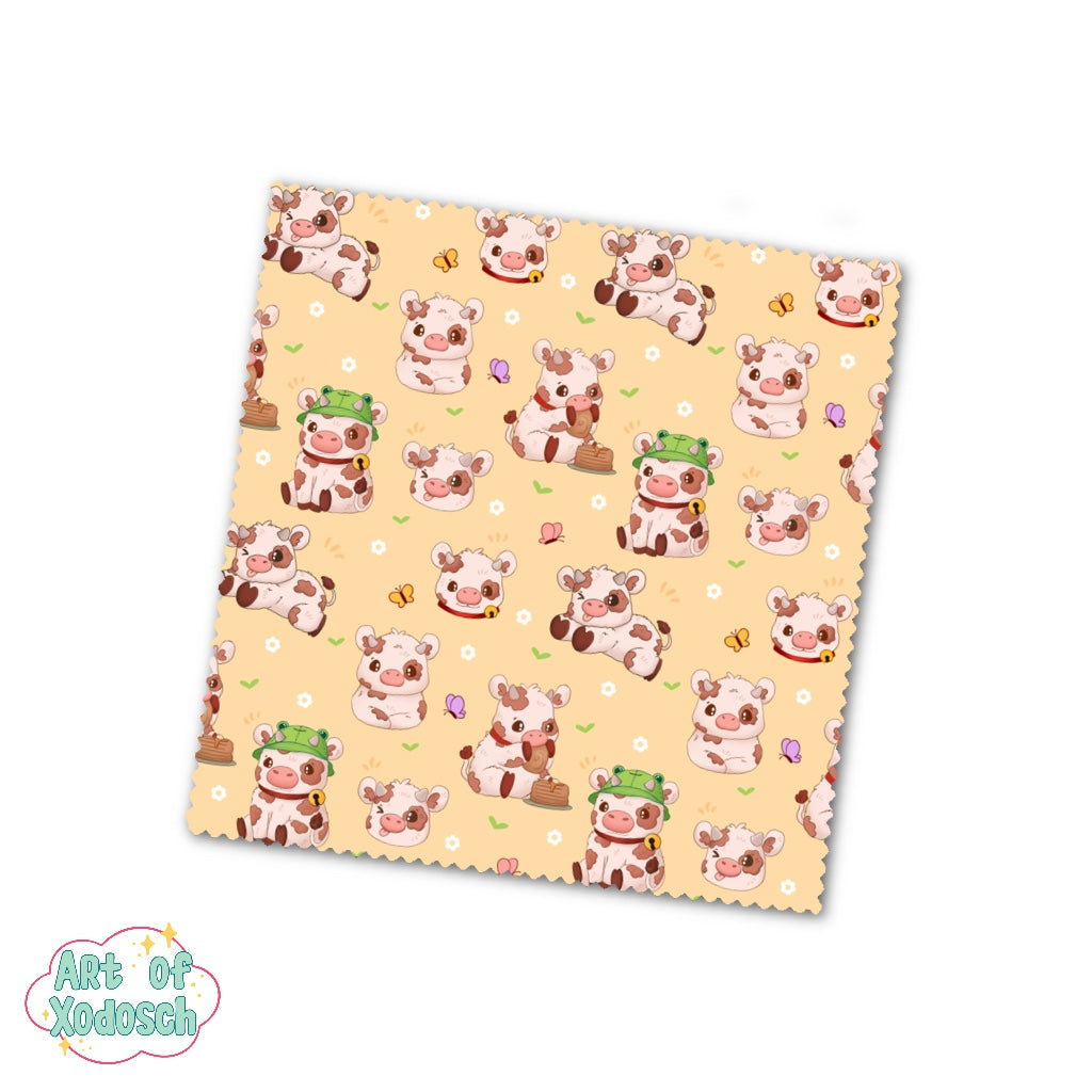 A cute microfiber cloth with cows, flowers and butterflies on a soft yellow background to clean your glasses